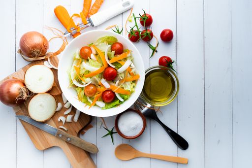 A top view of a healthy salad with vegetables and onions