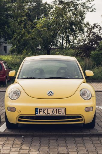 Yellow new Volkswagen Beetle car parked on a parking spot