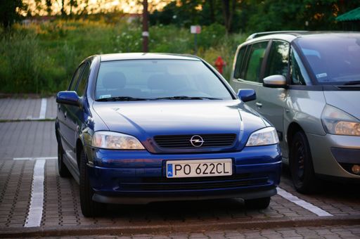Parked blue Opel car on a parking spot