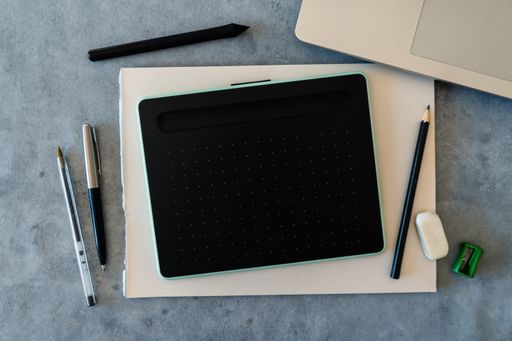 A top view of the graphic tablet of drawing on a blank sheet with traditional drawing tools