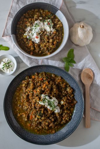 A vertical shot of bowls of delicious homemade lentil dal soup on a table