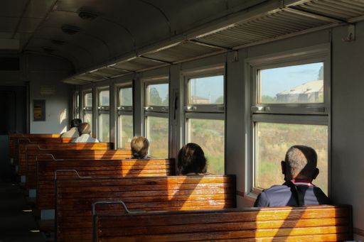 A group of people looking outside the window through train windows