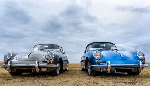 A closeup shot of grey and blue cars put next to each other under a cloudy sky