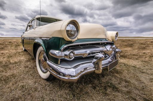 A closeup shot of a vehicle on a dry field under a cloudy sky