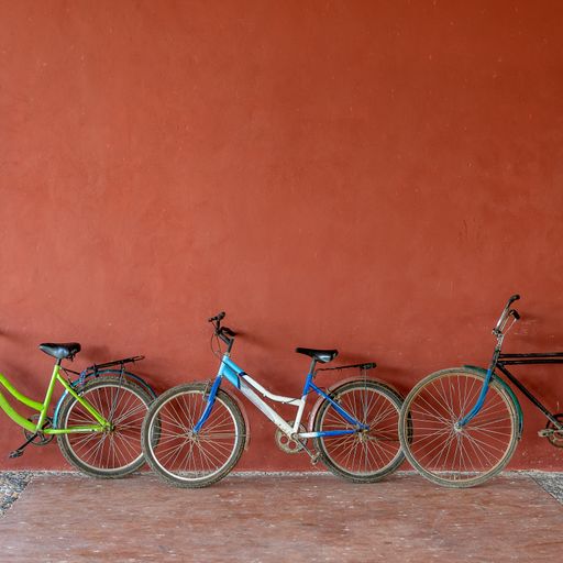 A wide angle shot of multicolored bicycles put on an orange wall
