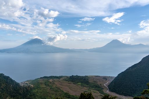 A wide angle shot of the mountains in front of the ocean under a clear blue sky 
 in Guatemala
