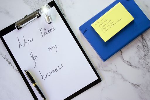 A top view of a notepad with a to-do list and a lamp on a marble surface