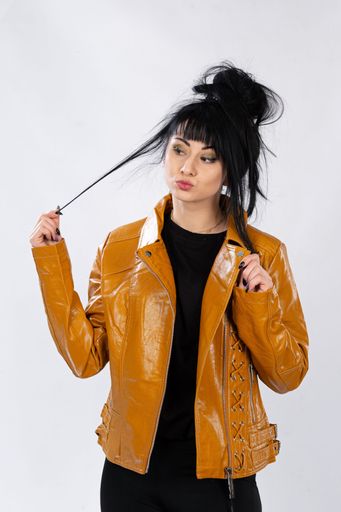 A fashion model from Bosnia and Herzegovina in a leather jacket posing against a white background