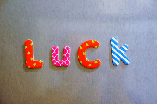 The word luck made of colorful magnetic letters on a brown background