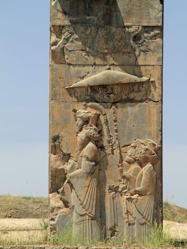 A vertical shot of a statue carved on stone during daytime