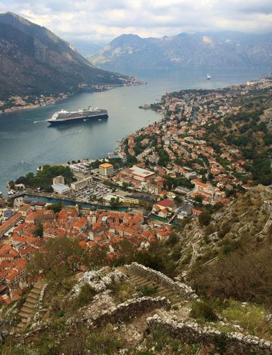 A vertical shot of a ship sailing through the Kotor Fortress in Montenegro