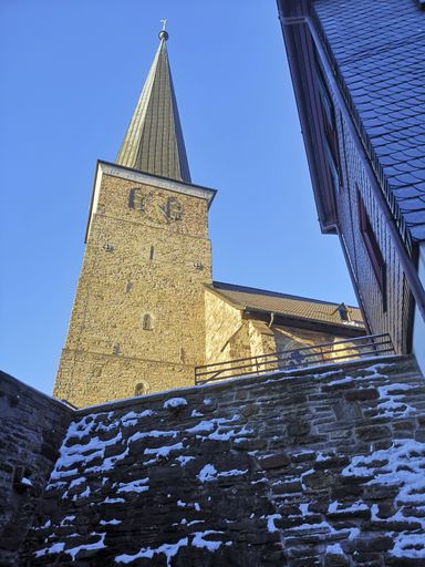A vertical shot of the St. Peter's church in Mulheim Ruhr on a snowy day with blue sky