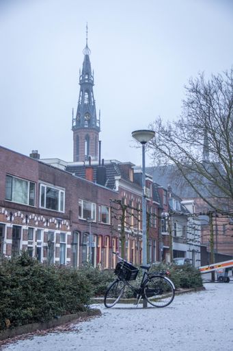 A vertical shot of buildings with the tower of St. Joseph Cathedral in Groningen Netherlands in the background