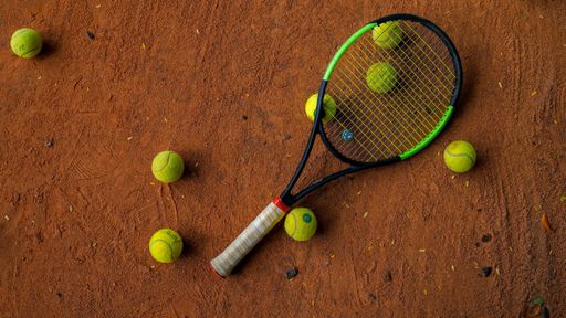 A top view of tennis racket and balls on a tennis court
