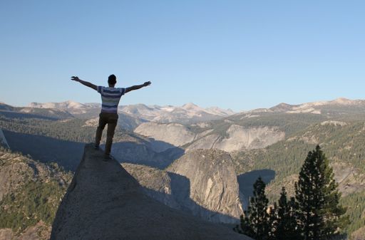 A wide angle shot of a man standing near the Yosemite National Park, USA
