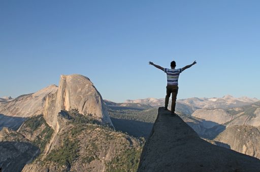 A wide angle shot of a man standing near the Yosemite National Park, USA