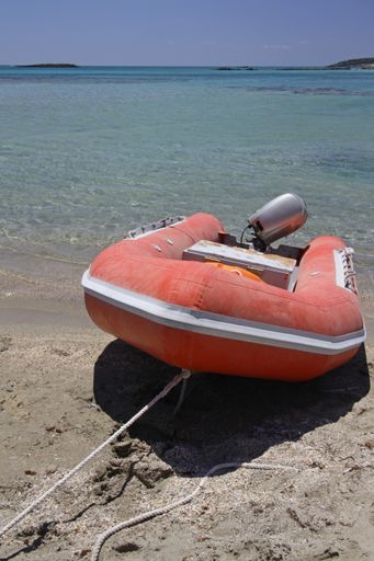 A vertical shot of a red jet ski on the beach during daytime