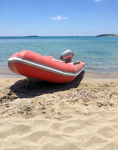 A vertical shot of a red jet ski on the beach during daytime