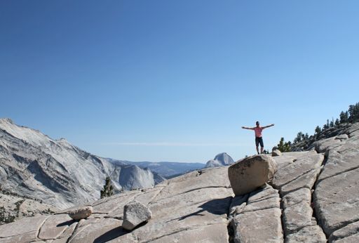 A wide angle shot of a man standing on a rock in Yosemite National Park, USA