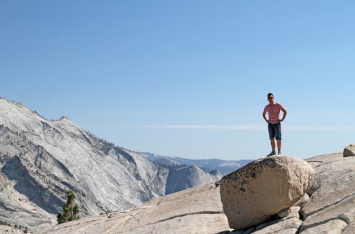 A wide angle shot of a man standing on a rock in Yosemite National Park, USA