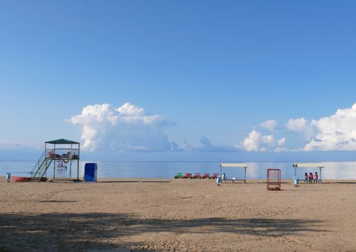 A wide angle shot of benches and small towers on the beach during daytime