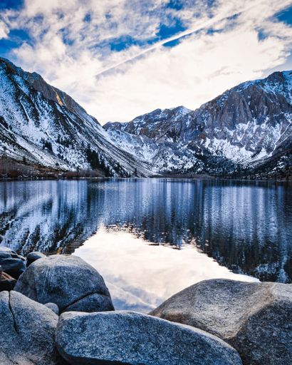 A mesmerizing view of the lake and snowy mountains against cloudy sky in Mammoth Lakes, California