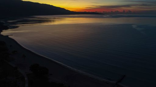 A wide angle shot of the beach under a darkening sky during the sunset