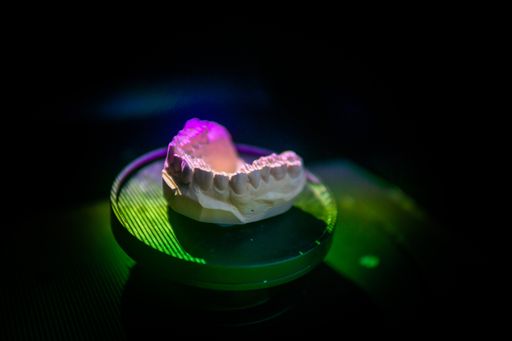 A closeup shot of a dental plaster model inside a scanner being scanned