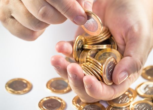 A man counting his savings, putting the Brazilian real coins on a white background