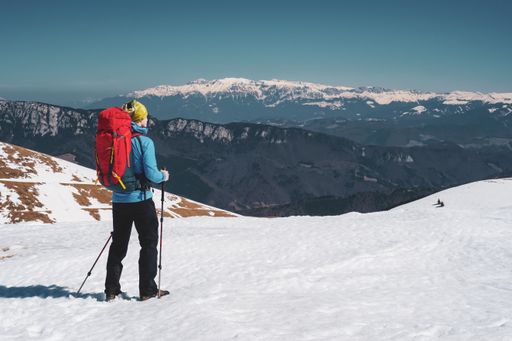 A beautiful shot of a man hiking in the snowy Carpathian Mountains in Romania