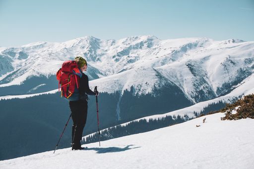 A male mountain climber enjoying  the snow covered mountain view from the summit
