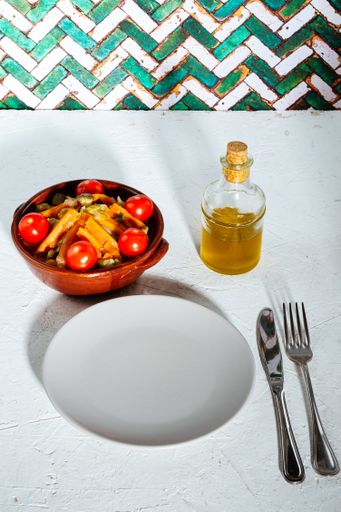A closeup view of a delicious-looking diner with tomato, carrots in a ceramic bowl