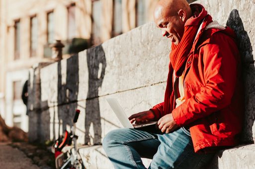 A young Latin male working with his laptop in the city of Lyon