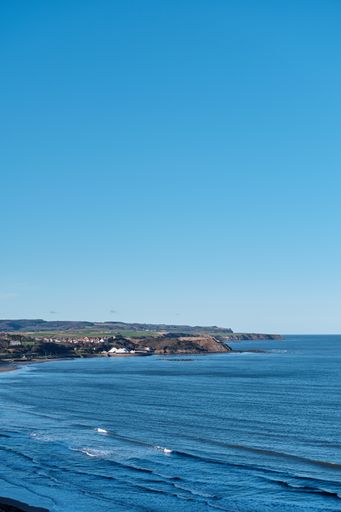 A vertical shot of a blue sea and a clear sky during daytime