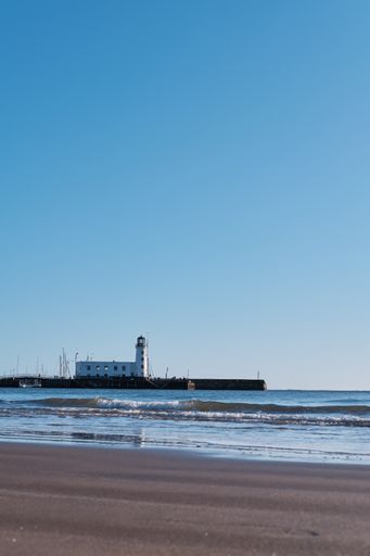 Vertical shot of the lighthouse on the coast of scarborough in north yorkshire on a bright cold cloudless sunny day in January