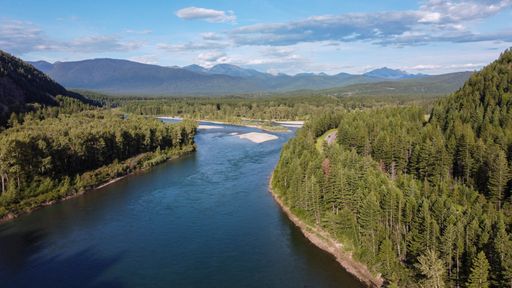 An aerial shot of a river and trees on the mountains, Glacier National Park, Montana, USA