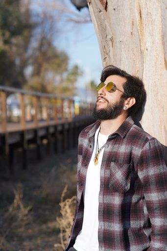A vertical shot of a handsome smiling Caucasian male in sunglasses posing for the camera