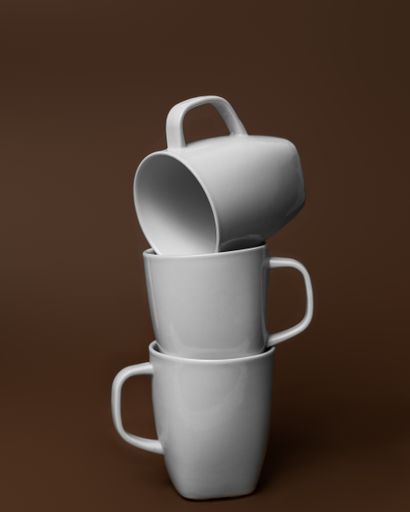A vertical closeup of white-colored mugs placed on top of each oth