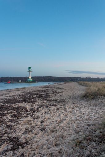 A wide angle shot of a tower on the beach under a clear blue sky