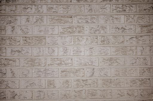 A closeup shot of a wall made of white rectangular stones having different patterns