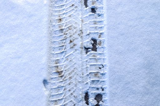A high angle of a tire track on a snowy road in winter