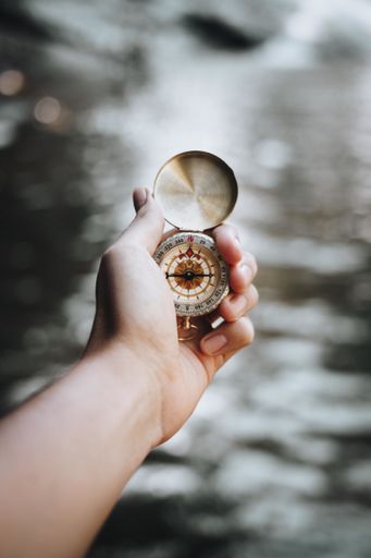 A vertical closeup shot of a person holding a compass