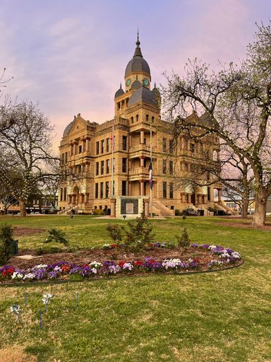 A vertical shot of the Denton County Courthouse in Texas, USA, featuring its impressive facade and columns