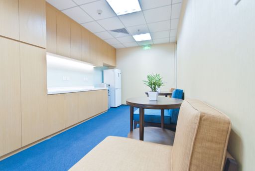 This stock photo features an empty business office environment with desks and chairs positioned in front of a window that overlooks a city landscape