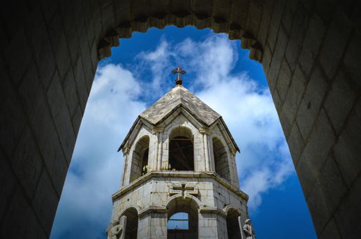A White Armenian Apostolic Cathedral with a blue sky in the background
