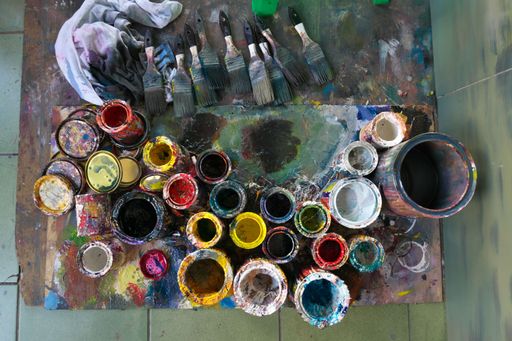 A well-organized table with a variety of paint brushes and paint cans, ready to be used for a painting project