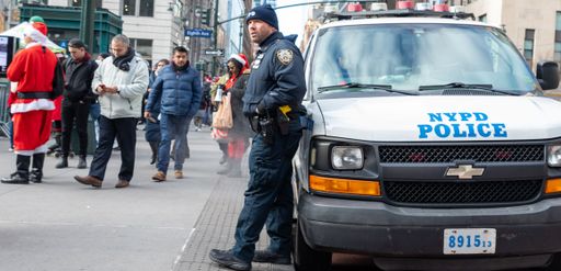 A police officer has stopped at a bus stop for directions