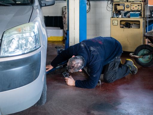 An auto mechanic repairing the car in his workshop
