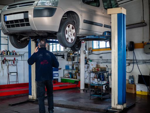 An auto mechanic repairing a car in his workshop