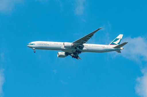 Cathay Pacific airliner approaching London Heathrow airport against a blue sky
